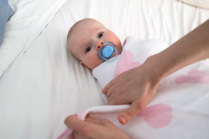 Pucken Baby wird fest in ein weiches Tuch eingewickelt